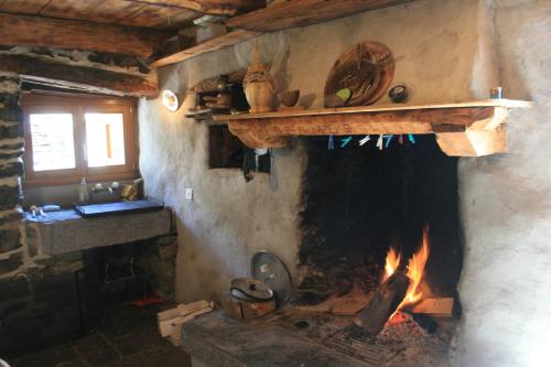 a fireplace in a kitchen with a fire place at Agri Scinghiöra in Brontallo