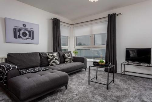 a living room with a couch and a television at Walker Suite No73 - Donnini Apartments in Kilmarnock