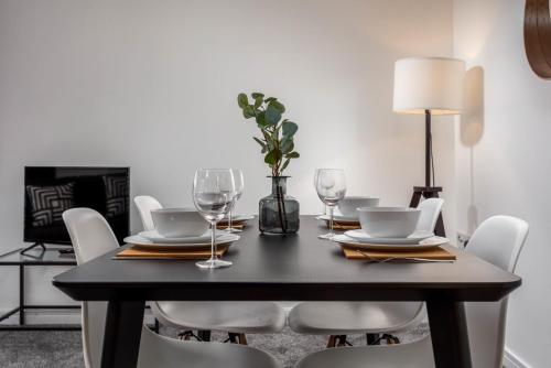 a black dining room table with white chairs and a lamp at Walker Suite No73 - Donnini Apartments in Kilmarnock