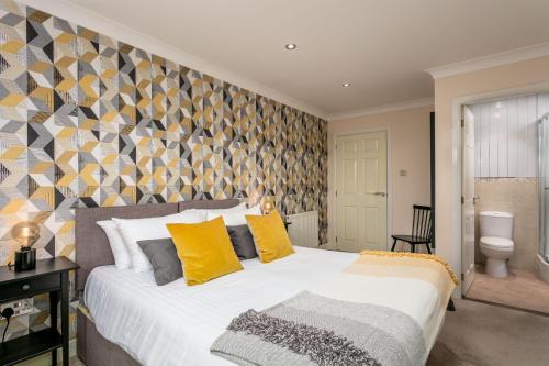 a bedroom with a large bed with yellow pillows at The Lucas - Donnini Apartments in Ayr