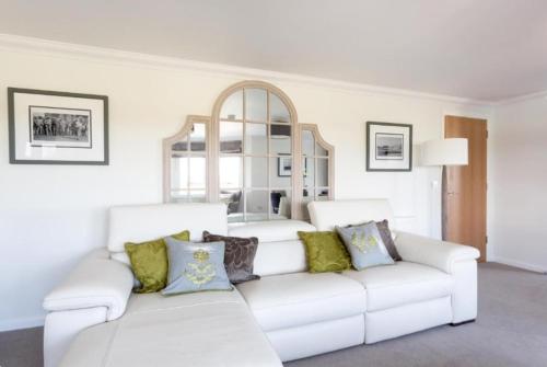 a white couch with colorful pillows in a living room at Links View - Donnini Deluxe in Prestwick