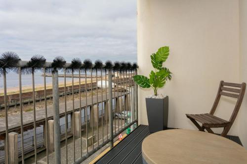 a balcony with a table and a view of the beach at Harris Retreat - Donnini Apartments in Ayr