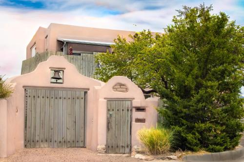 a pink house with a gate and a tree at Heart of Vibrant Railyard-Large Downtown Loft with Prime Location and Beautiful Deck in Santa Fe