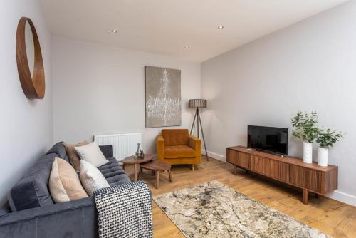 a living room with a couch and a television at Seafield House - Donnini Apartments in Ayr