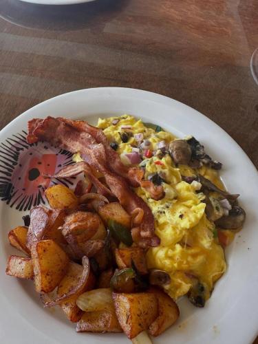 a plate of breakfast food with bacon and potatoes at The Mafolie Hotel in Mafolie