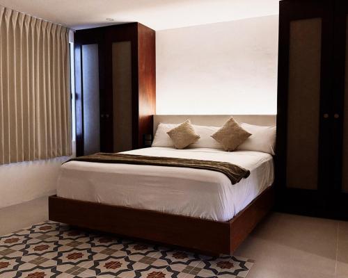 a bedroom with a large bed with white sheets and pillows at Casa San Martín, Campeche #2 in Campeche