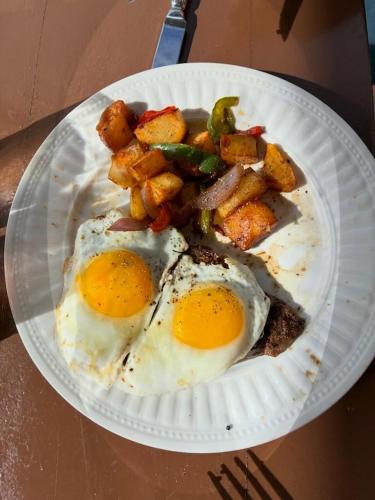 a paper plate with eggs and potatoes on a table at The Mafolie Hotel in Mafolie