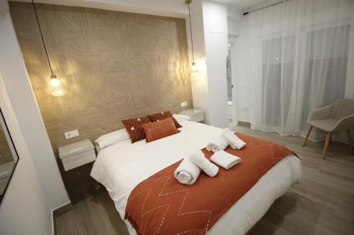 a bedroom with a large bed with towels on it at LaJoya De La Villa in Priego de Córdoba