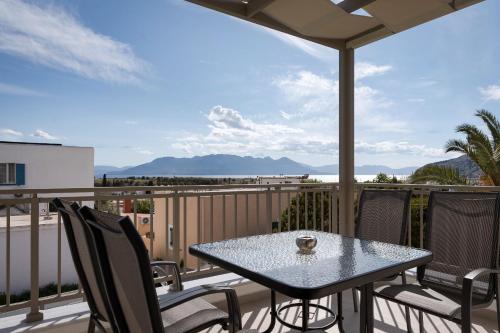 a table and chairs on a balcony with a view of the ocean at Fasma Suites in Perdika