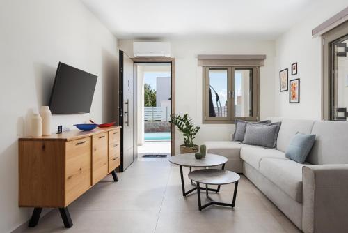 a living room with a couch and a tv at Fasma Suites in Perdika
