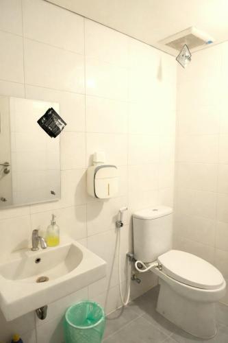 a white bathroom with a toilet and a sink at apartment candiland room 45 m2 in Jomblang