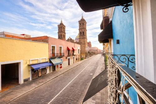 a view from a balcony of a street with two towers at Hotel Puebla Plaza in Puebla