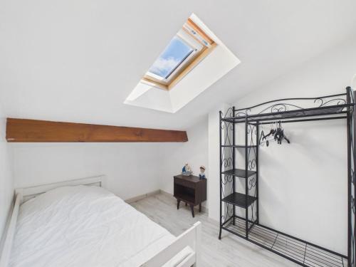 a bedroom with a bed and a skylight at Maison avec piscine à 200m de la plage in Saint-Michel-Chef-Chef