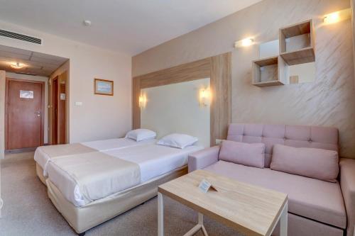 a hotel room with a bed and a couch at Paraiso Beach - All Inclusive in Obzor