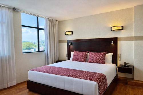 a bedroom with a large bed with a large window at Hotel Alifer in Tlaxcala de Xicohténcatl