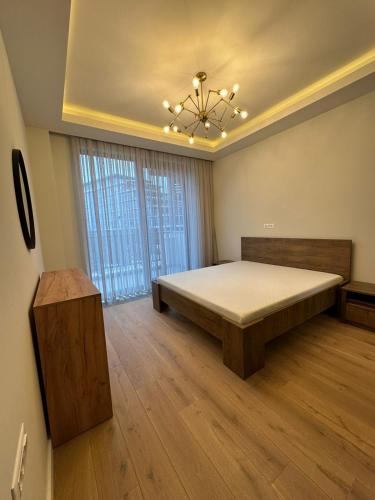 a large bedroom with a bed and a chandelier at Tatilçi Baba in Mekhrably