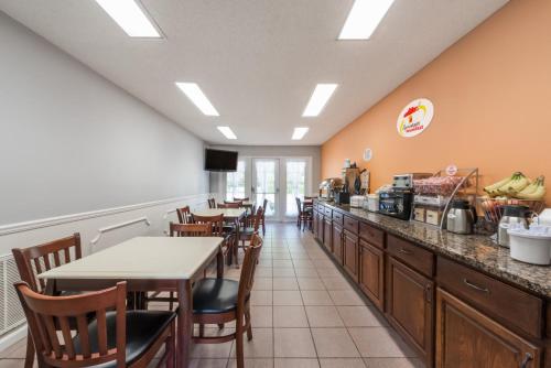 a restaurant with a counter and tables and chairs at Super 8 by Wyndham Alexander City in Alexander City