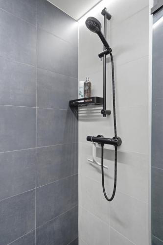 a shower with a black shower head in a bathroom at Relax al Mare with sauna near the sea in Laulasmaa