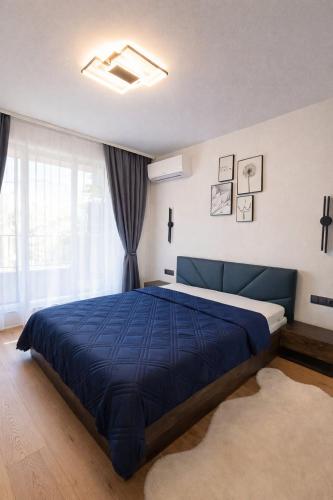 a bedroom with a blue bed with a blue blanket at Boutique apartment 4 in Plovdiv