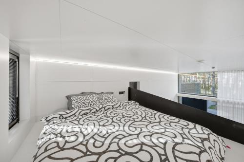 a white bedroom with a black and white bed at Relax al Mare with sauna near the sea in Laulasmaa