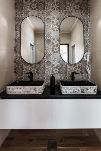 two sinks in a bathroom with two mirrors at Villa Sunce in Visoko