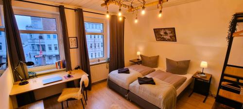 a bedroom with a bed and a desk and windows at Elite-Apartment am Hauptbahnhof Celle mit Küche,Privat-Parkplatz,Waschmaschine und 5G WLAN für 6 Personen in Celle