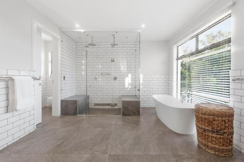 a white bathroom with a tub and a sink at Tuna Room in Ballito