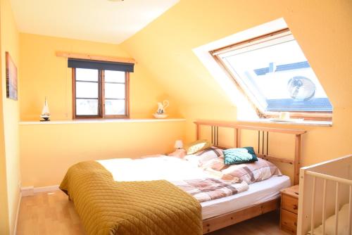 a small bedroom with a bed with a window at Ferienwohnung Ankerpladsen Jolle in Behrensdorf