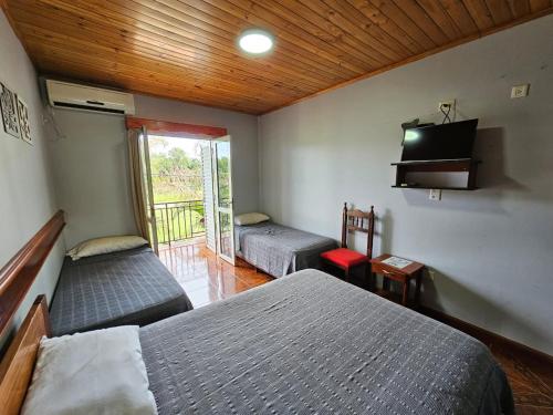 a bedroom with two beds and a television in it at Hotel Amatista in Wanda