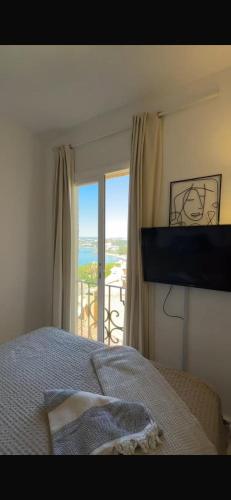 a bedroom with a bed and a view of the ocean at Apartament w Esteponie in Estepona