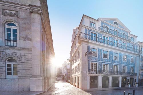 a building with the sun shining behind it at Europe Lisboa Boutique Hotel in Lisbon
