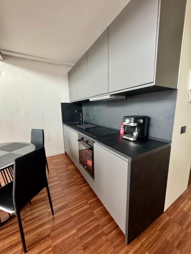 a kitchen with a black and white counter and a table at Private Luxury Loft in Crescenzago