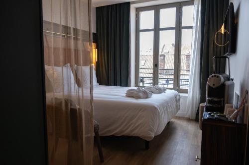 a hotel room with a bed and a large window at Hotel & Spa Oceania Lille Les Augustins in Lille