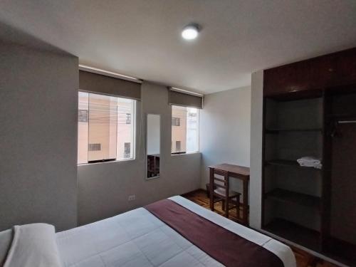 a bedroom with a bed and a desk and a window at MNk HOTEL in Arequipa