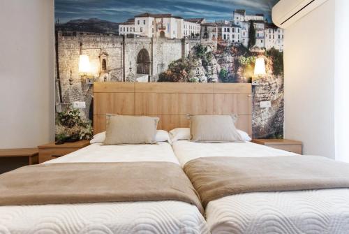 two beds in a bedroom with a wall mural at Hotel El Tajo & SPA in Ronda