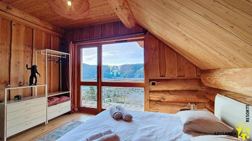 a bedroom with a bed and a large window at Chalet Trappeur 8 Personnes in Beaune