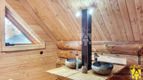 a bathroom with two sinks in a wooden cabin at Chalet Trappeur 8 Personnes in Beaune