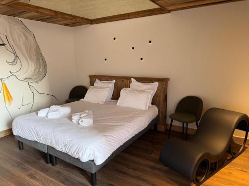 a bedroom with a bed and a chair in it at L'évasion in Saint-Jean-dʼArvey