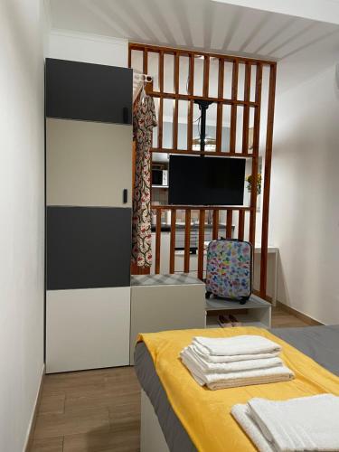 a bedroom with a bed and a tv in a room at Casa das Férias in Lisbon
