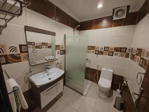 a bathroom with a sink and a toilet at فندق تاج النخبة - Taj Nakhba Hotel in Jazan