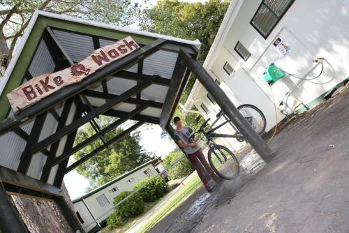a person standing next to a bike next to a building at Rotorua Thermal Holiday Park in Rotorua