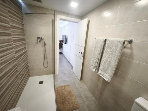 a bathroom with a shower and a toilet and towels at VIP private Poolsuite Calafell in Calafell