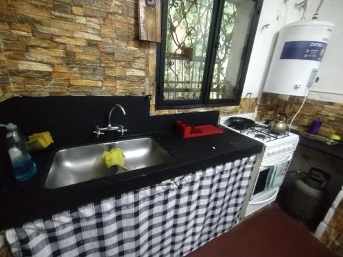 a kitchen with a sink and a stove at Depto Brochero in Mina Clavero