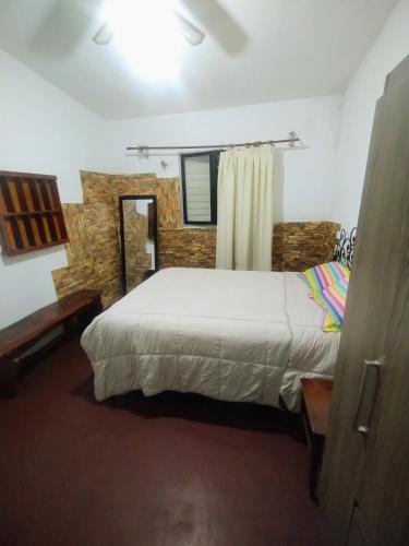 a bedroom with a large white bed and a window at Depto Brochero in Mina Clavero