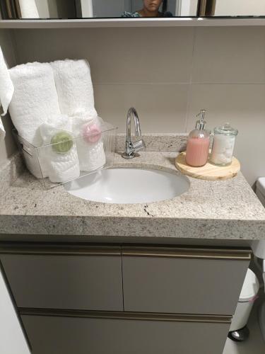 a bathroom counter with a sink and towels at Alugo QUARTO em Apartamento -Centro de Recife in Recife