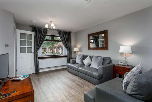 a living room with a couch and a table at The Huntington - Donnini Apartments in Ayr