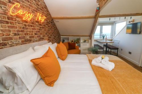 a bedroom with a large bed with a brick wall at Seagulls Nest in St Ives