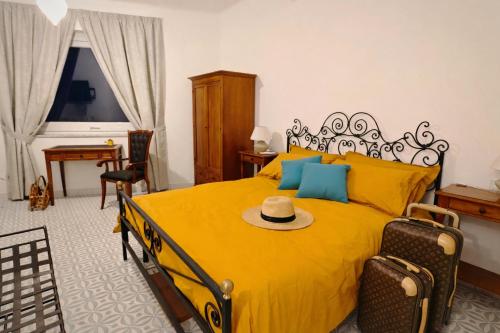 a bedroom with a yellow bed with a hat on it at Campagnano Rural Suite & Spa in Ischia Town