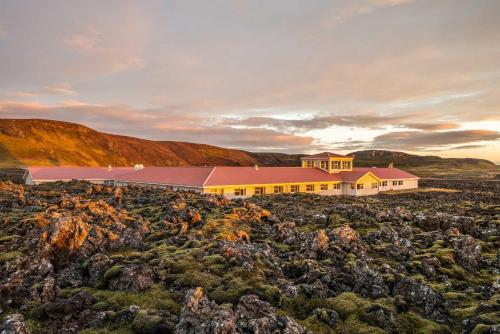 a large building in a field of rocks at Northern Light Inn in Grindavík