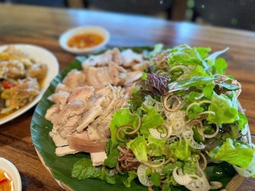 a plate of food with a salad on a table at Dhami Farmstay, Đông Giang, Đà Nẵng in Danang